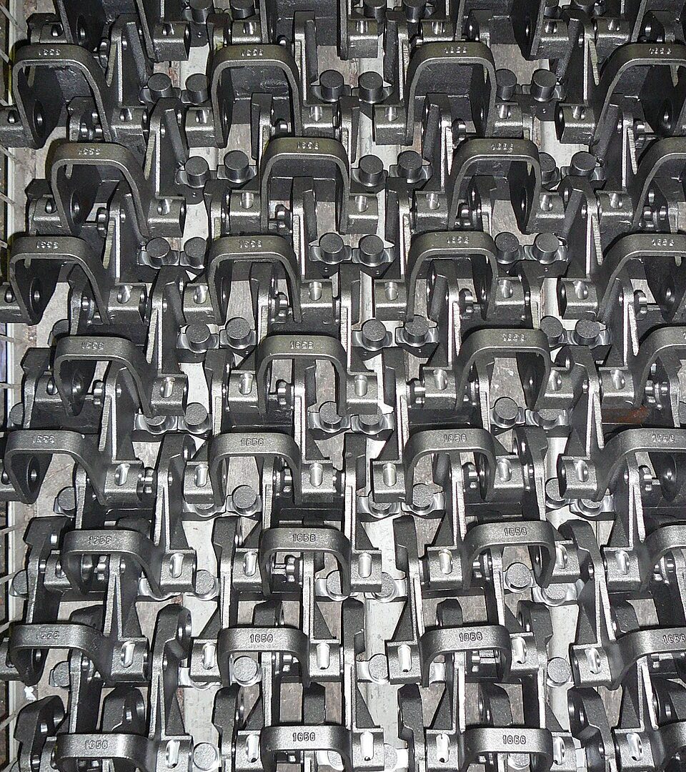 A rack of batch-produced forged and machined steel parts