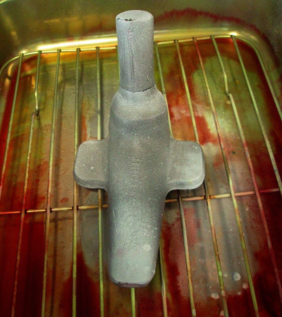 A steel forging on an inspection rack showing a crack indication found by magnetic-particle inspection