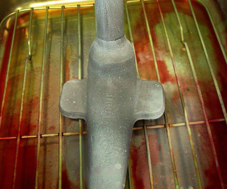 A steel forging on an inspection rack showing a crack indication found by magnetic-particle inspection